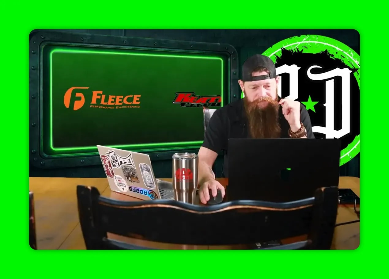 Studio host at desk with the Fleece Performance logo clearly visible on the green screen behind him.